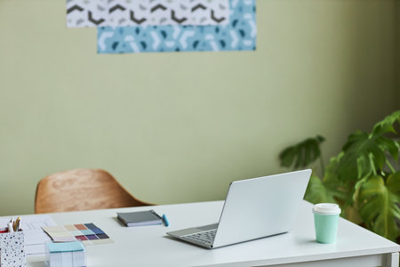 Minimal office workplace with pastel green wall in background, copy spaceの写真素材