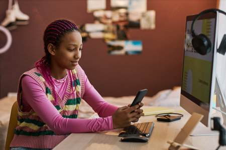 Side view portrait of black teenage girl using smartphone at home and texting friends