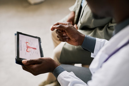 Close up of doctor holding tablet with female reproductive organ charts, copy spaceの写真素材