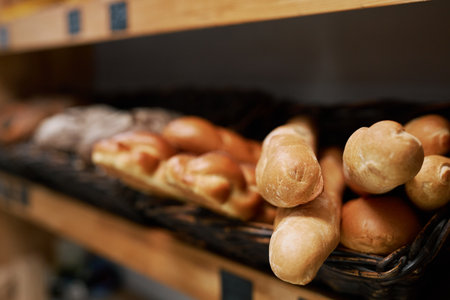 Various types of freshly baked bread on shelves in bakery