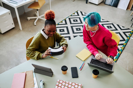Top view at two creative young people developing VR software in office