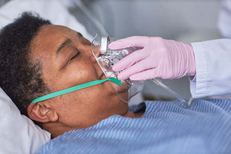 Close up of nurse placing oxygen support mask on senior patient in hospital roomの写真素材