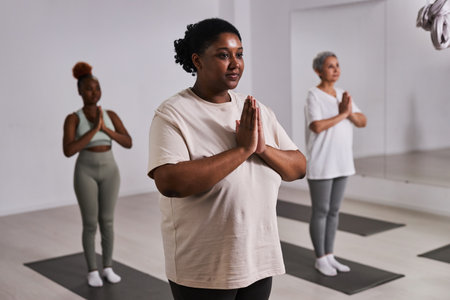 Group of overweight women doing yoga together during training in health clubの写真素材