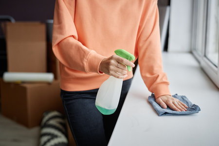 Close-up of young woman using detergent to do housework in her new apartment after relocationの写真素材
