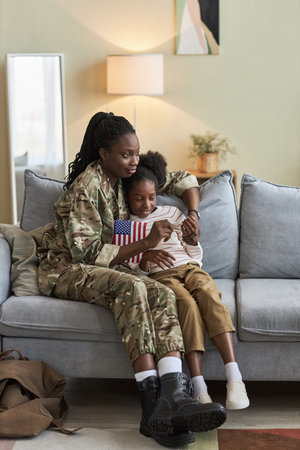 Vertical image of African American mother spending time together with daughter at homeの写真素材