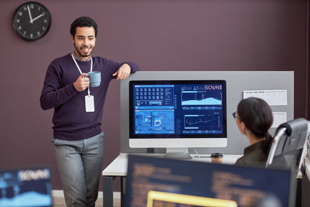 Portrait of smiling man chatting with colleague at coffee break in IT company office, copy space