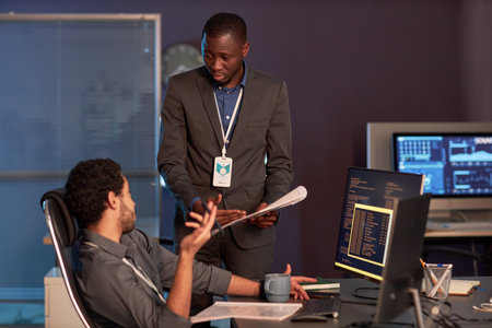 Portrait of two IT engineers discussing documentation at workplace in officeの写真素材