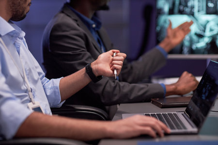 Close up of man using laptop in meeting at security agencyの写真素材