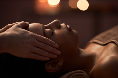 Masseuse gently touching face of young woman when applying skin treatmentの写真素材