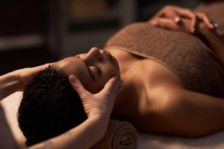 Cosmetologist gently massaging face of young womanの写真素材