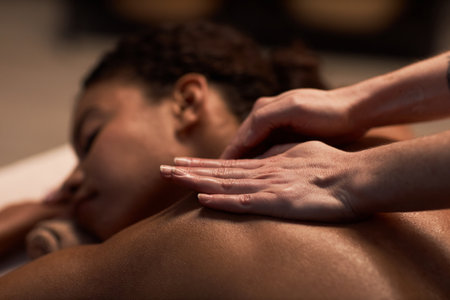 Closeup image of masseuse massaging neck of female clientの写真素材