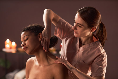 Masseuse massaging neck of young woman that prevents tension and painの写真素材