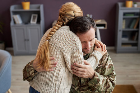 Candid portrait of girl embracing military dad at home in bonding momentの写真素材