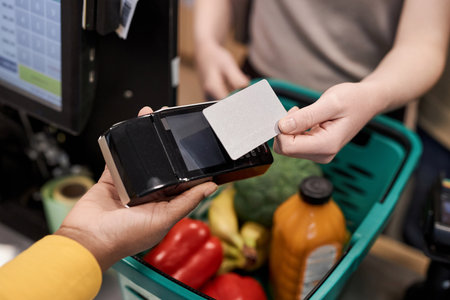 Unrecognizable young woman using credit card mockup paying for groceries in supermarket, copy spaceの写真素材