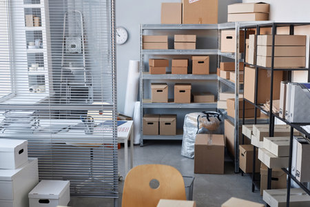 Part of spacious warehouse with stacks of packed cardboard boxes containing goods ordered by clients of online shopsの写真素材