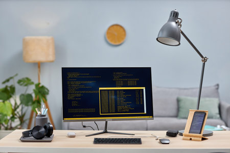Background image of computer screen with code lines on modern workplace with mobile devices, copy spaceの写真素材