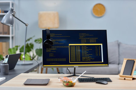 Background image of software programming workplace at home office with code on computer screen, copy spaceの写真素材