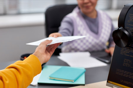 Close up of two young people handing document across table in office while collaboration on IT project, copy spaceの写真素材