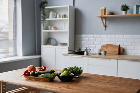 Background image of fresh vegetables ready for cooking on wooden table in minimal kitchen interior, copy spaceの写真素材