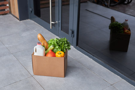 Background image of box with fresh groceries outdoors on house porch, copy spaceの写真素材