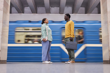 African American couple meeting in subway and talking while waiting for the trainの写真素材
