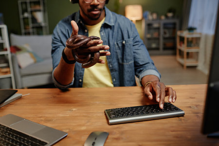 Close-up of young businessman with rat snake enlacing his hand pressing key of computer keyboard while sitting by desk in front of monitorの写真素材
