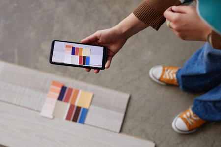 High angle view of designer making photo of different colors of flooring on her smartphoneの写真素材