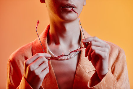 Close-up of fashion model posing with sunglasses against colored backgroundの写真素材