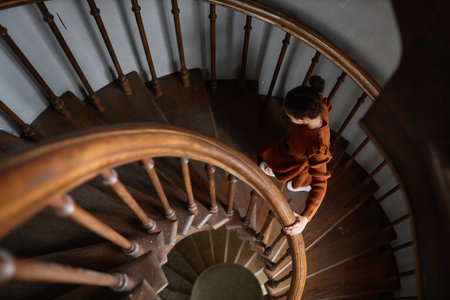High angle view of little girl going up the wooden stairs