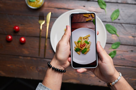 Top view of photographer making photo of food on mobile phone for food blogの写真素材