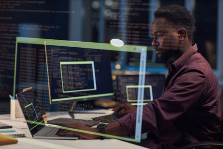 Professional developer writing codes for program on computer while working in office till late...