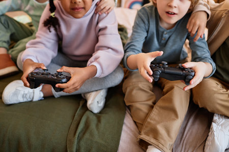 Closeup of children playing videogames together and holding controllers