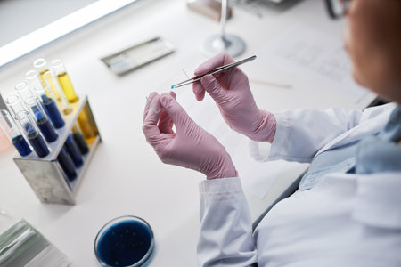 Top view closeup of female scientist preparing test material while doing research in laboratory, copy spaceの写真素材