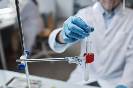 Closeup of scientist holding dropper and test tube while doing experiments in laboratory, copy spaceの写真素材