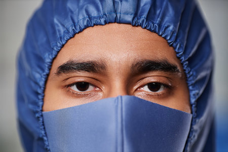 Macro shot of medical worker wearing full protective gear looking at camera over maskの写真素材