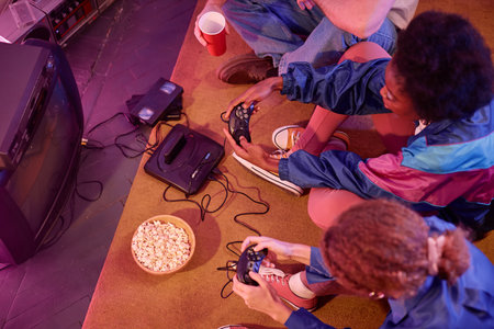 Top view of young people playing retro video game in neon light 80s style, copy spaceの写真素材