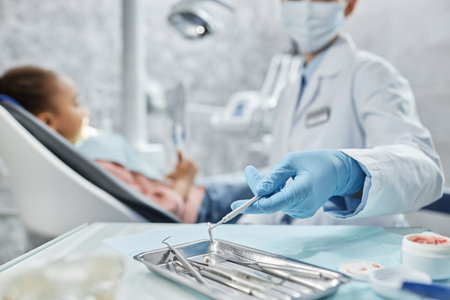 Closeup of female dentist holding sterile metal tools while working with child in dental clinic, copy spaceの写真素材