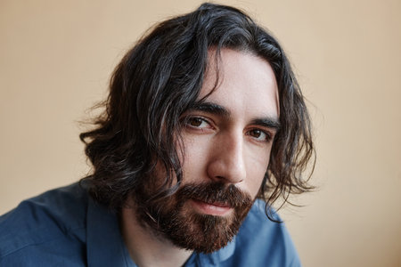 Closeup portrait of real middlle aged man with long hair looking at camera with confidence