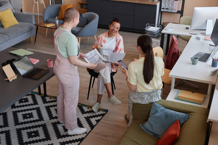 High angle view at all female business team in office focus on young black woman smiling