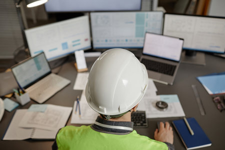 Top view of engineer wearing hardhat at workplace in office and using computer , copy spaceの写真素材
