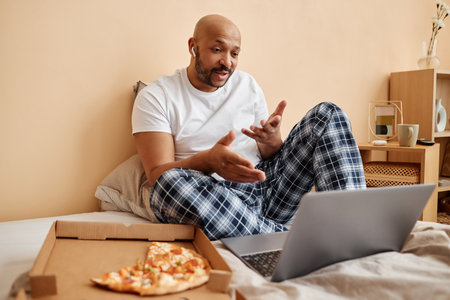 Portrait of black man enjoying laze weekend at home and talking via video chat, copy spaceの写真素材
