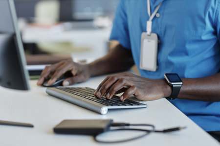 Focus on left hand of young African American male software developer touching keys of computer...