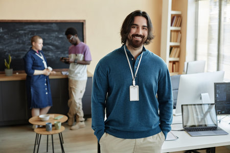 Young successful businessman in quiet luxury attire looking at camera with smile while standing...