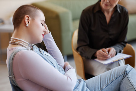 Teenage girl listening to recommendations of psychologist during her visit to officeの写真素材