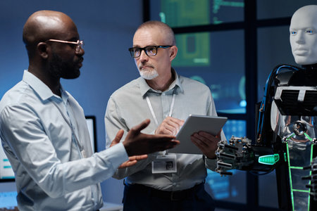 Multiethnic engineers using digital tablet to work with artificial intelligence in team in officeの写真素材