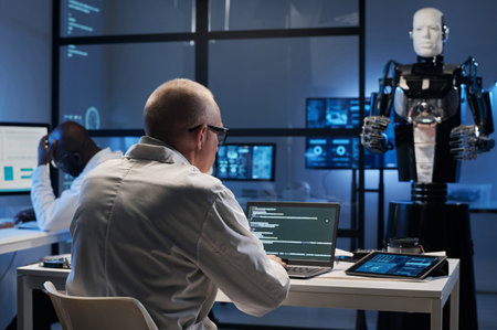 Rear view of mature developer writing codes on laptop for developing artificial intelligence during...