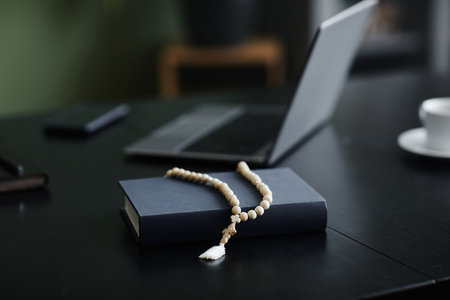Close up of rosary over Bible on workplace desk in office, copy space
