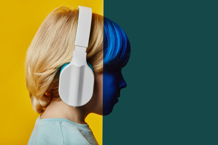 Side view of blond boy in headphones standing in front of camera in between yellow and vintage green...