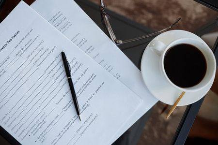 Top view background image of contracts and coffee cup on glass table in office, copy spaceの写真素材