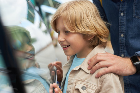 Close up of little boy buying ice cream with father in amusement parkの写真素材